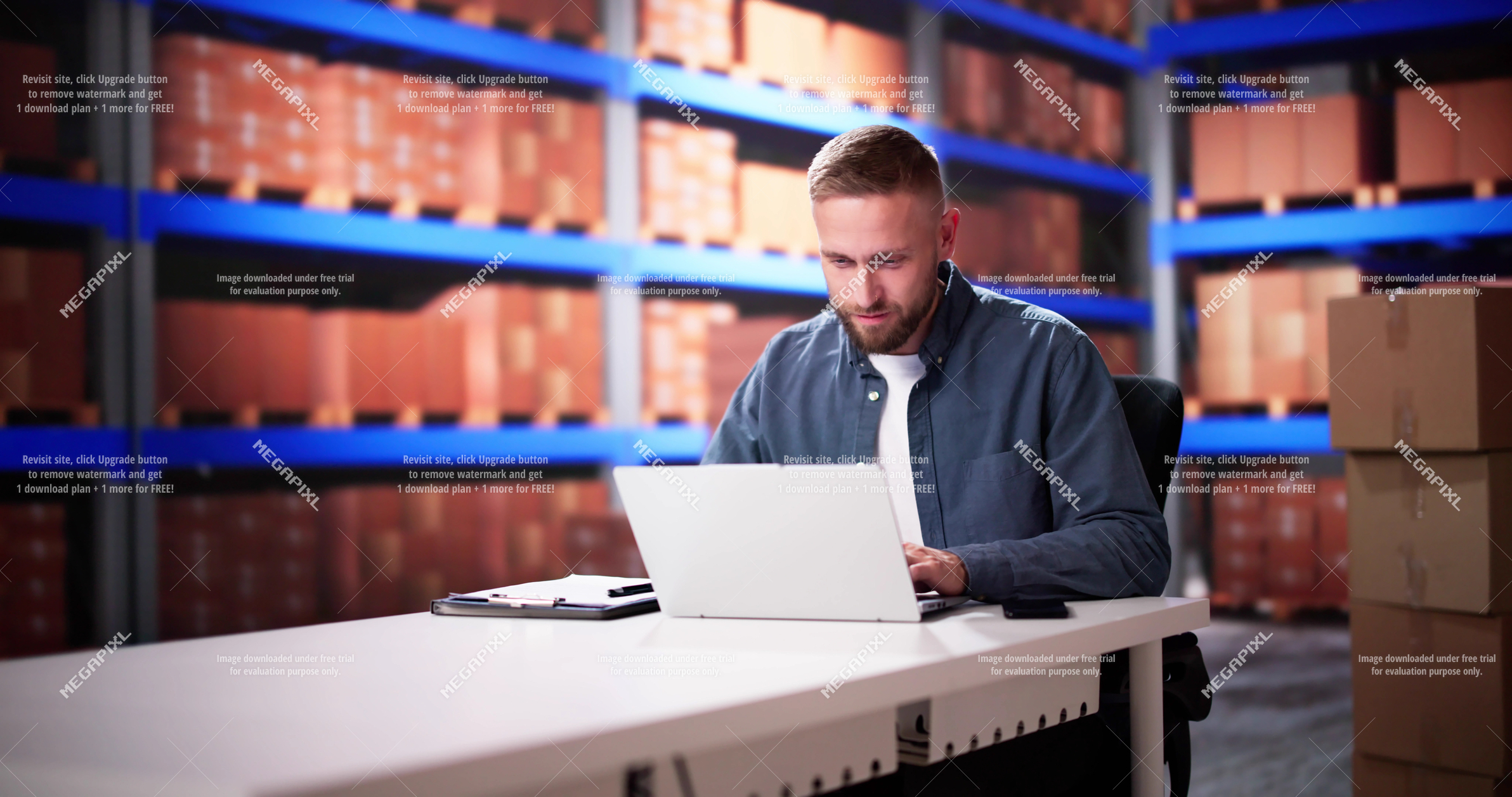 Business professional using a laptop in a warehouse