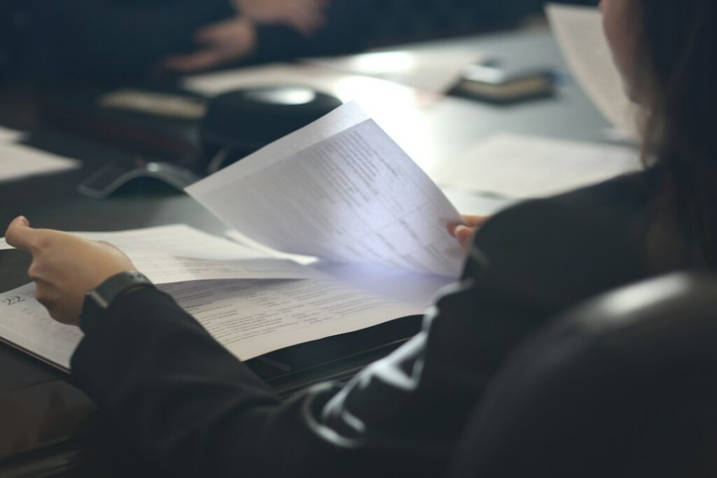 A person reviewing business documents at a desk.