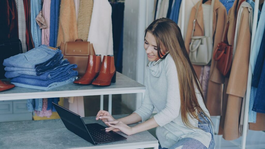Retail workspace with a laptop and clothing inventory.